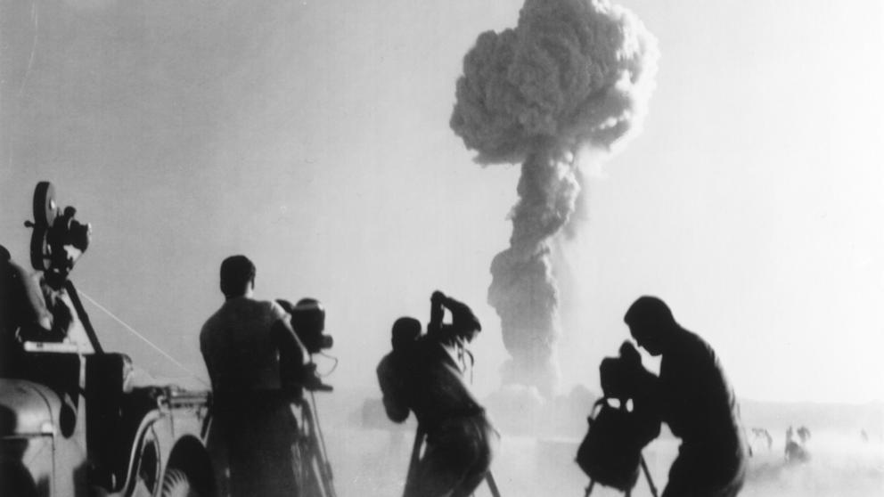 Un grupo de cámaras en el momento de captar una explosión nuclear en el desierto de Nevada, en 1957 (Interim Archives / Getty)